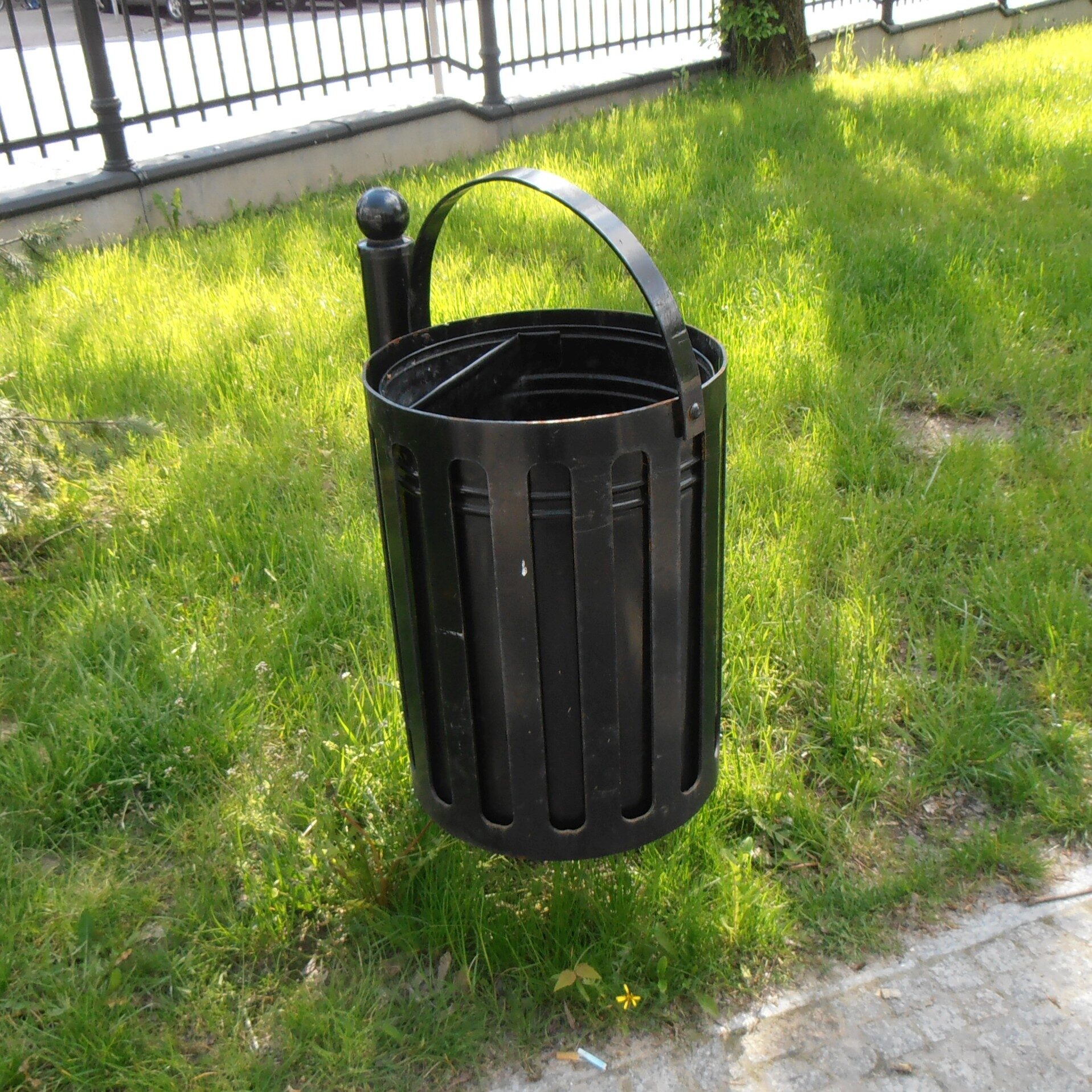 Metalowy kosz uliczny w parku.