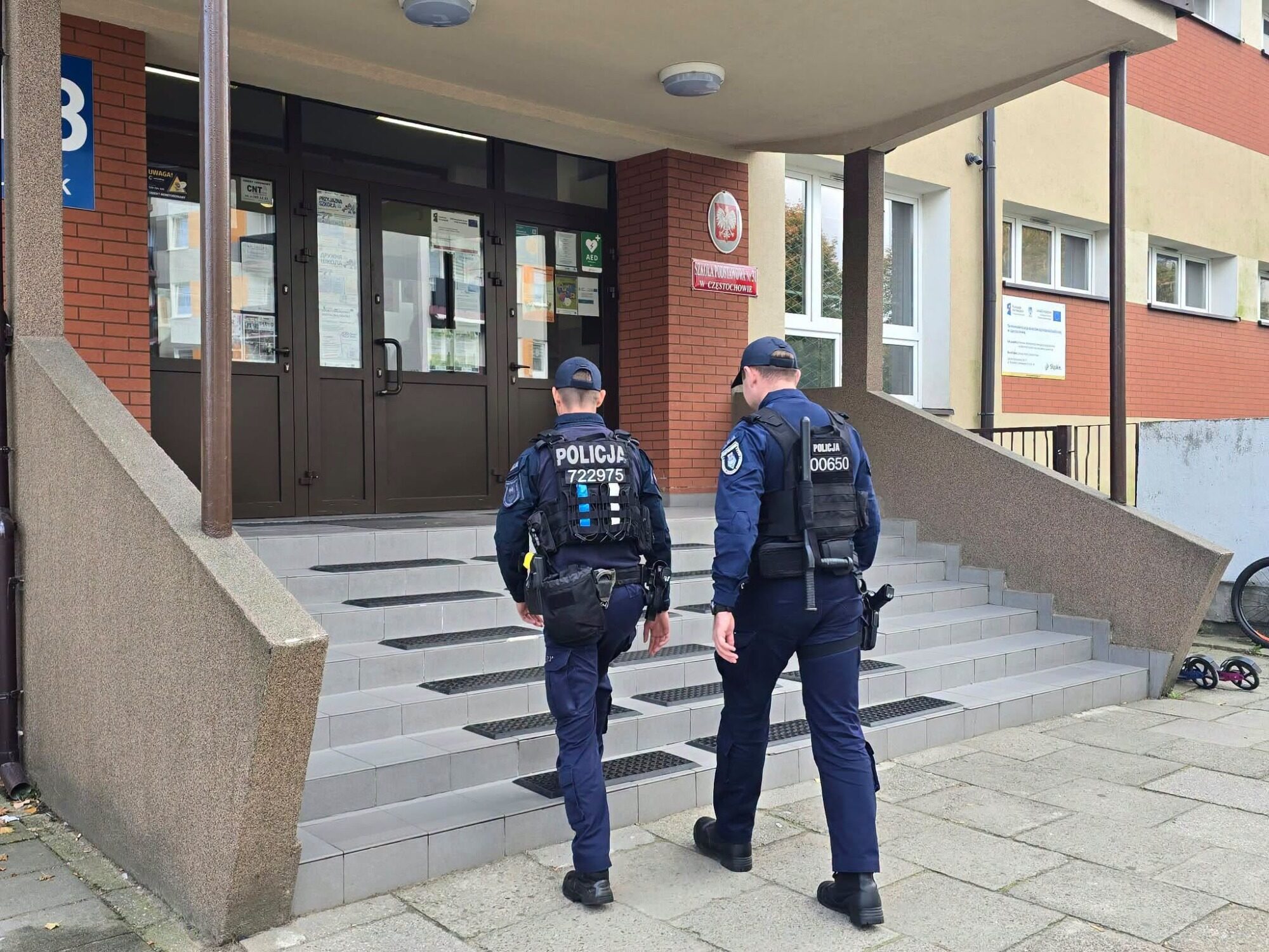 Dwaj policjanci przed wejściem do szkoły. Zdjęcie ilustracyjne.